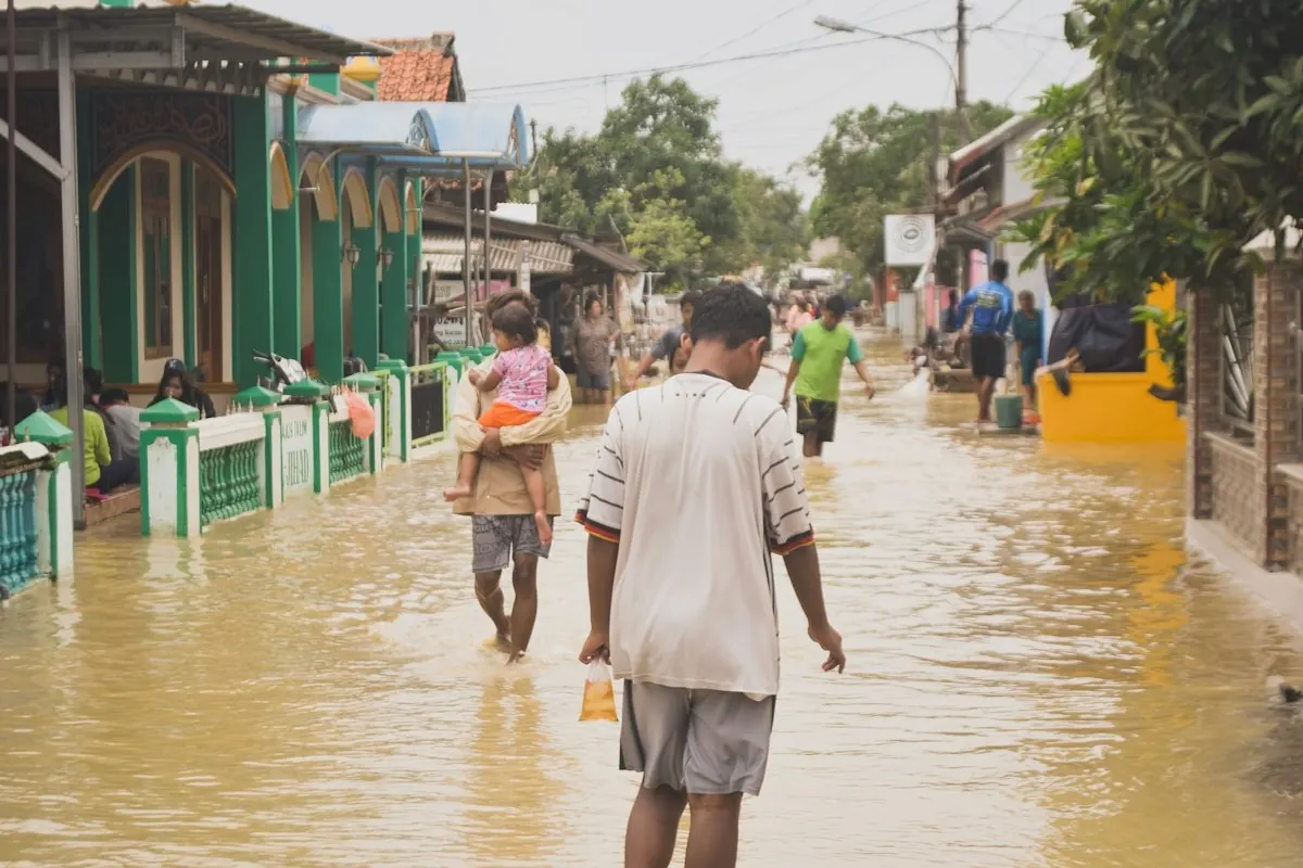 Families moving through a flooded neighborhood