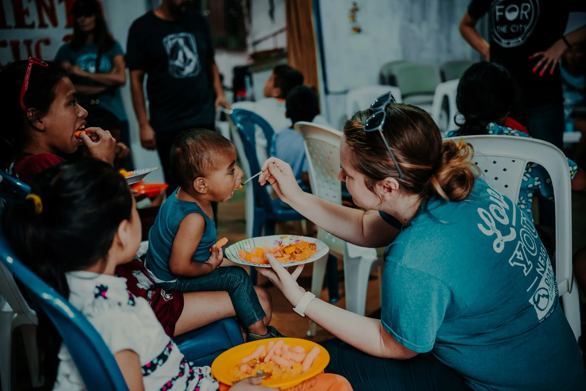 Community volunteer serving meals to children